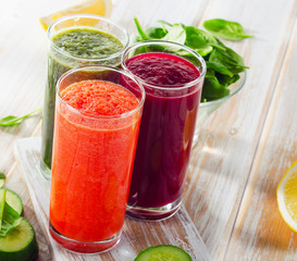 fresh vegetable juices on wooden background.