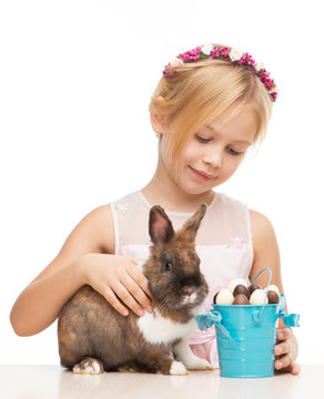 Smiling girl caressing little bunny