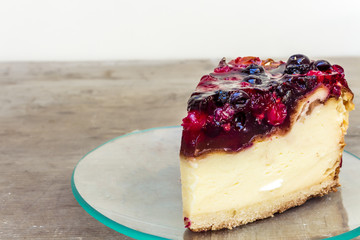 Cheesecake with strawberries in a plate on a wooden table