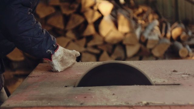 Man chopping firewood with circular saw. Slow motion