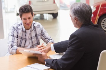 Salesman showing client where to sign the deal