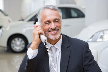 Smiling businessman making a phone call