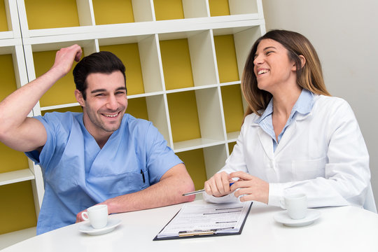 Young Couple Of Doctor And Nurse Having A Break And Relaxing Wit