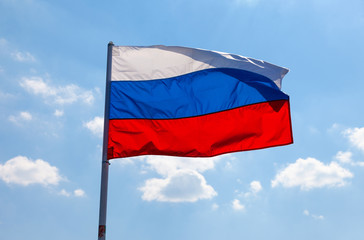 Russian flag waving in the wind over blue sky