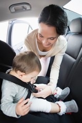 Mother securing her baby in the car seat