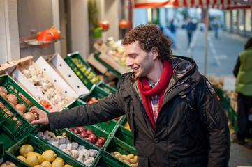 Junger mann beim einkaufen am Gemüse und Obststand 