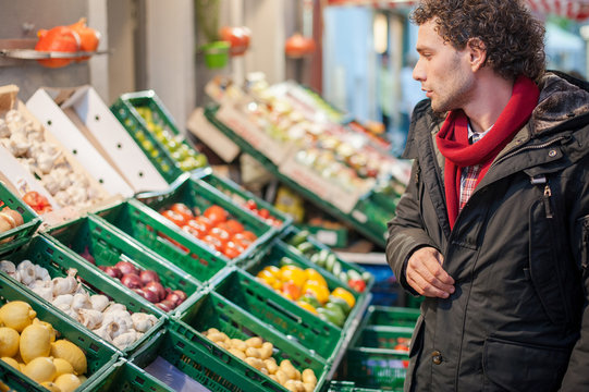 Junger mann beim einkaufen am Gemüse und Obststand 