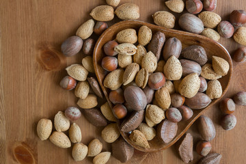 Mixed nuts in shells in wooden dish