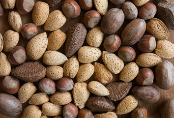Mixed nuts in shells on wooden surface