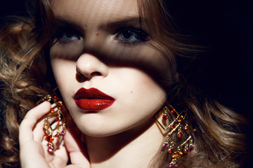 Fototapeta premium Beautiful sexy woman party makeup gold earrings red lips shadows