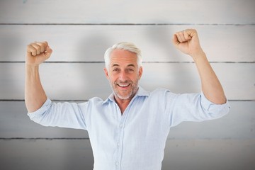 Composite image of smiling man cheering at camera