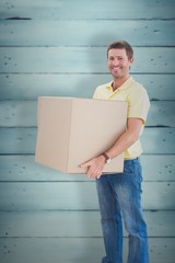 Composite image of man holding moving boxes