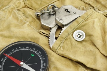 Compas and Handcuffs On The Weathered Backpack