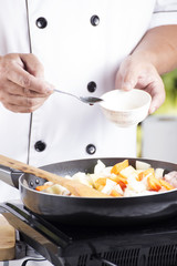 Chef putting seasoning sauce to the pan for cooking Japanese por