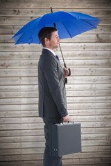 Serious businessman holding his umbrella