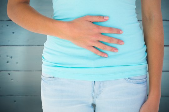 Composite image of slim woman with hand on stomach