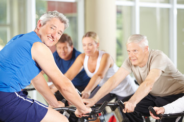 Trainer mit Senioren im Fitnesscenter