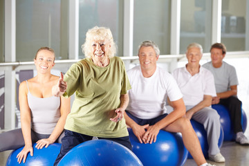 Alte Frau im Fitnesscenter hält Daumen hoch
