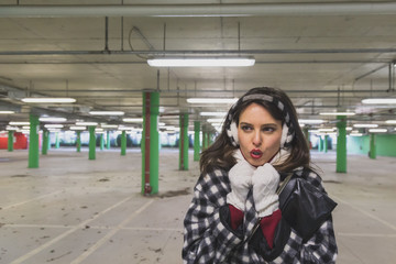 Beautiful young brunette posing in a parking garage