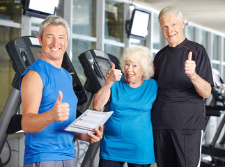 Paar Senioren im Fitnesscenter hält Daumen hoch