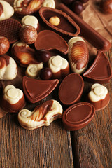 Different kinds of chocolates on wooden table close-up