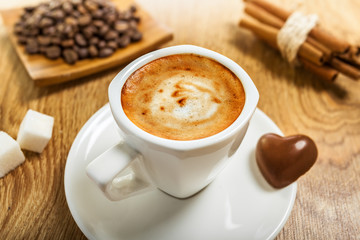 Cup of coffee with candy heart, sinnamon and sugar