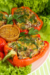 Stuffed red peppers on plate on napkin close up