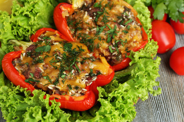 Stuffed red peppers with greens and vegetables on table close