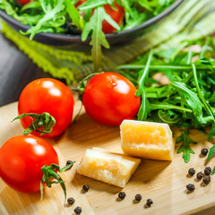 Food preparation, tomato rucola and Parmesan salad