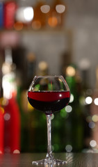 Glass of red wine with bar on background