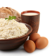 Dairy products with eggs and loaf of bread isolated on white
