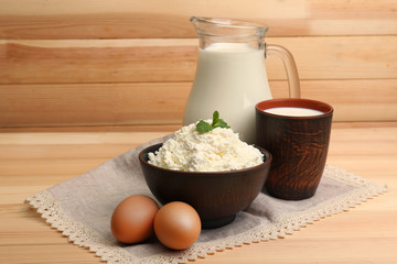 Cottage cheese in clay bowl with jug of milk and eggs
