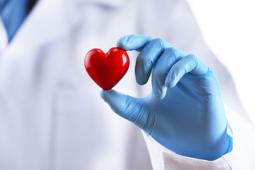 Doctor with stethoscope and small heart in hand