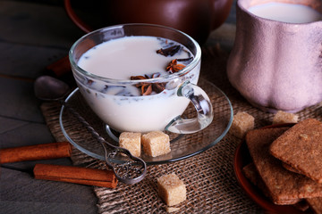 Black tea with milk in cups and teapot with lump sugar