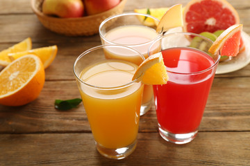 Fresh juices with fruits on wooden table