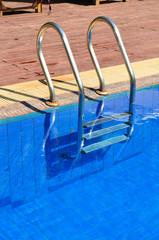 Swimming pool with metal ladder