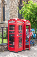 Fototapeta na wymiar Row of two red british telephone boxes