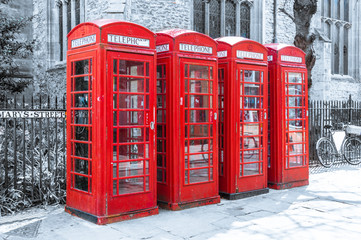 Obraz premium Row of red british telephone boxes on desaturated background