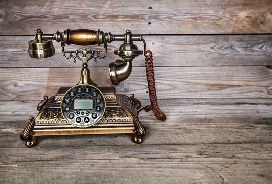 Old telephone on wooden background. Copy space on the bottom.