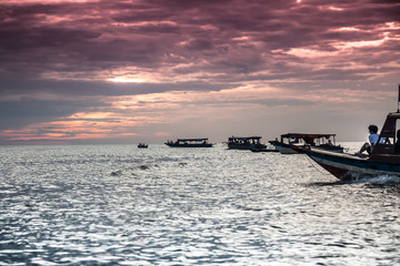 Obraz premium Boats sail towards the sunset