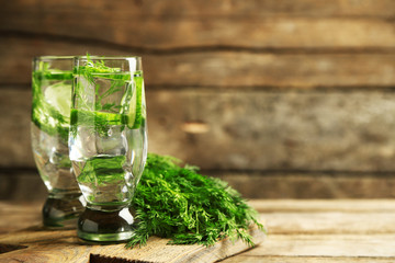 Glasses with fresh organic cucumber water on wooden table