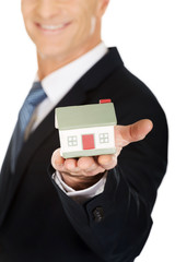 Businessman holding house model