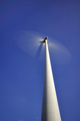 Grande éolienne en mouvement sur fond de ciel bleu