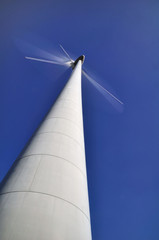 Naklejka premium Pales d'une éolienne en mouvement avec un ciel bleu