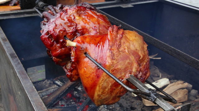 Roast pork leg on grill.