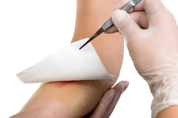 Medical assistant changes the dressing of a wound at the - obrazy, fototapety, plakaty