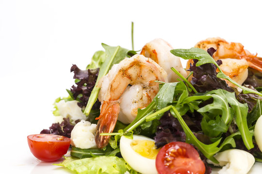 salad greens and shrimp on a white background in the restaurant