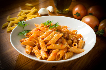 Penne with pork meat and tomato sauce, Italian cuisine