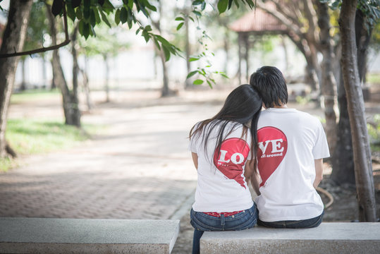 Loving couple sitting on a park bench together.
