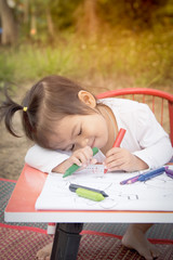 Cute little girl is painting in garden in soft style